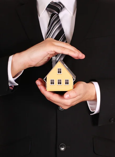 Wohngebäudeversicherung. Hausmodell in Geschäftsmannshand. — Stockfoto