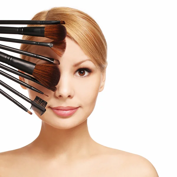 Beautiful woman with makeup brushes near attractive face — Stock Photo, Image