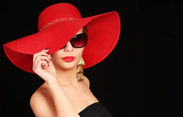Mujer con sombrero rojo y gafas de sol sobre fondo negro — Foto de Stock