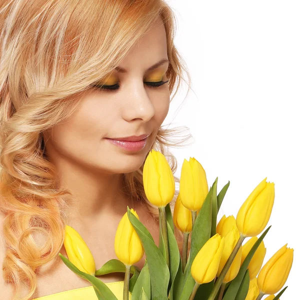 Блондинка с желтыми тюльпанами, изолированная на белом — стоковое фото