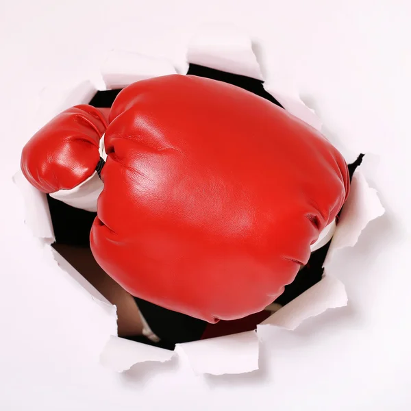 Ruku v Boxerské rukavice otvorem papíru — Stock fotografie