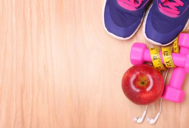 Spor donatımı. Spor ayakkabı, halter, ölçüm bandı, elma
