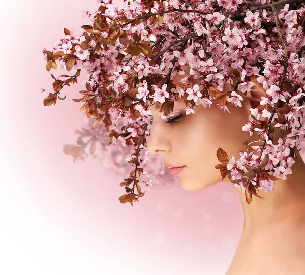 Frühlingsmädchen. schöne Frau mit Kirschblüte im Haar — Stockfoto
