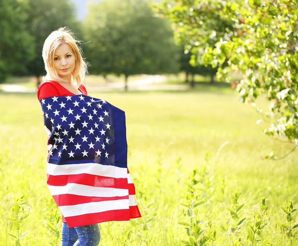 Όμορφη πατριωτικό νεαρή γυναίκα με αμερικανική σημαία. Εξωτερική — Φωτογραφία Αρχείου