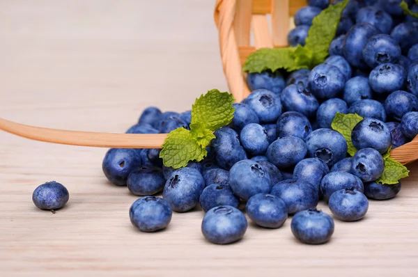 Bleuets dans le panier sur une table en bois — Photo