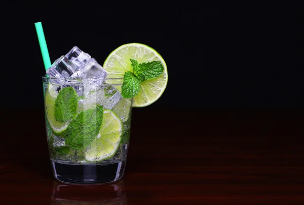 Mojito-Cocktail im Glas mit Minze auf schwarzem Hintergrund — Stockfoto