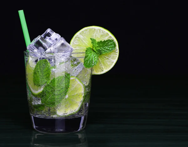 Mojito-Cocktail im Glas mit Minze auf schwarzem Hintergrund — Stockfoto