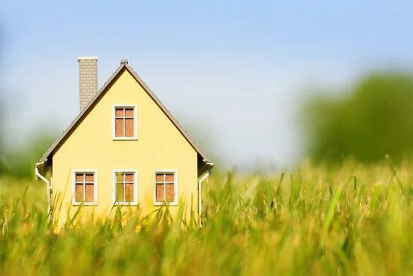 Casa in erba verde sopra il cielo blu. Concetto ipotecario — Foto Stock