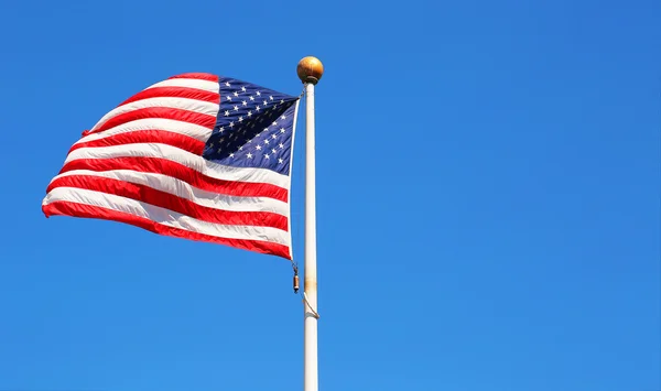 Amerikaanse vlag zwaaiend in blauwe lucht — Stockfoto