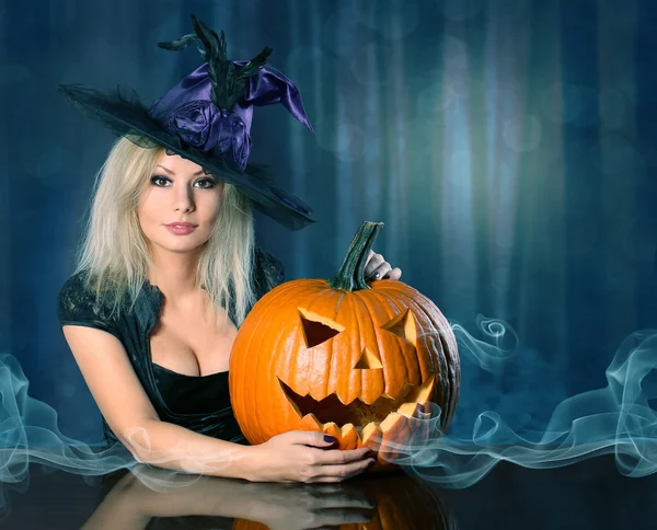 Witch met Halloween pompoen. Prachtige blond meisje — Stockfoto