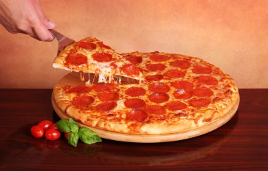 Bir dilim biberli Pizza alarak el