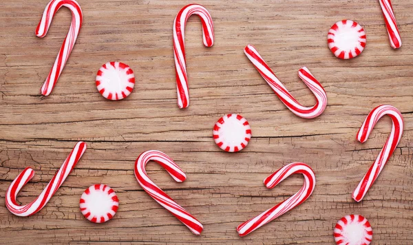 Christmas. Peppermint Candy and Canes on old wooden background