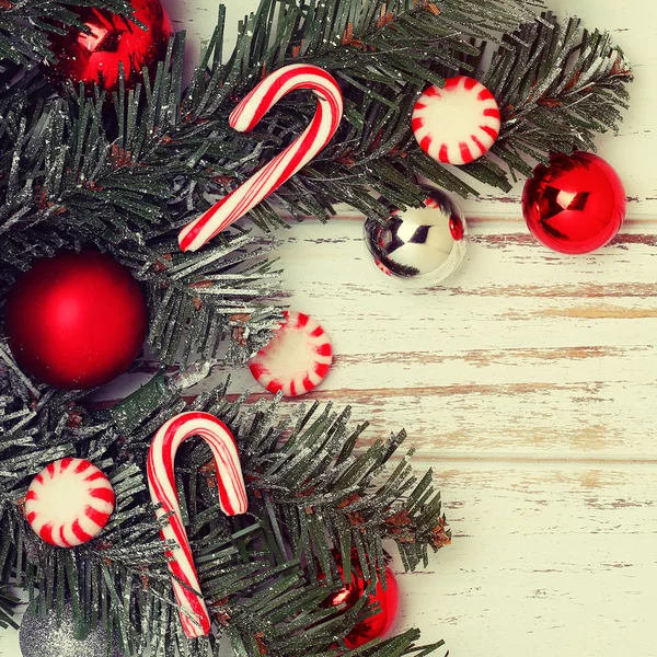 Rama de árbol de Navidad con bolas rojas y cono de caramelo —  Fotos de Stock