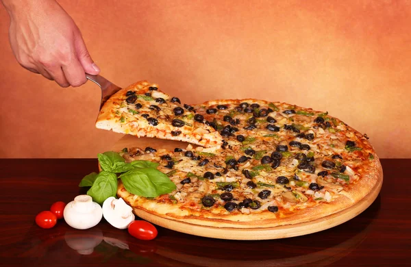 Hand ta en bit Veggie Pizza — Stockfoto