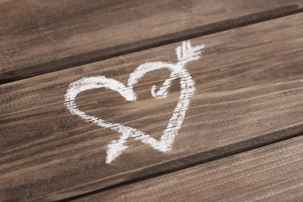 Сердце со стрелкой, нарисованной мелом на деревянном фоне — стоковое фото