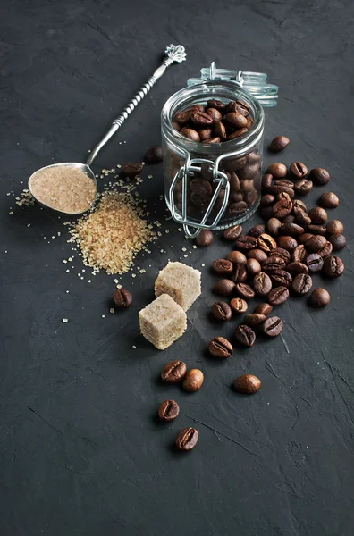 Koffiebonen in een glazen pot en bruine rietsuiker — Stockfoto