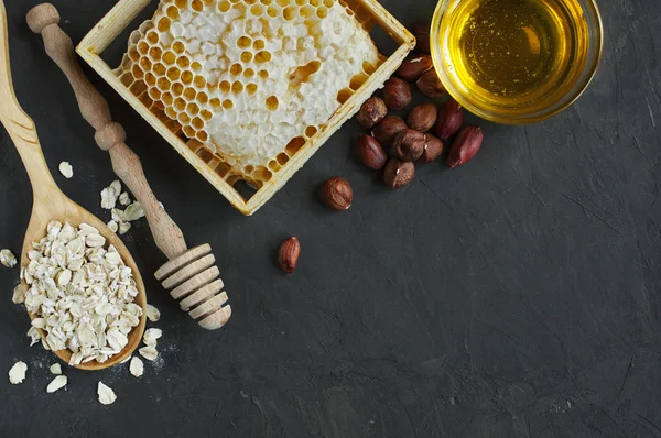 Honeycomb and nuts, and oatmeal and wooden dipper — Stock Photo, Image