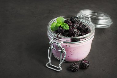 Yoğurt ve siyah ahududu cam kavanozda