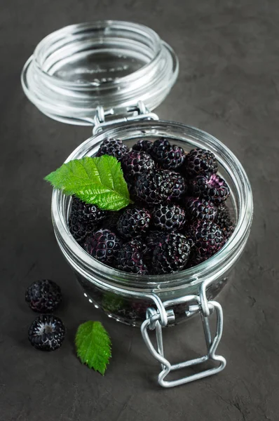 Frambuesas negras en un frasco de vidrio — Foto de Stock