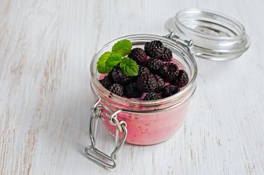 Siyah ahududu bir cam kavanoza yoğurt