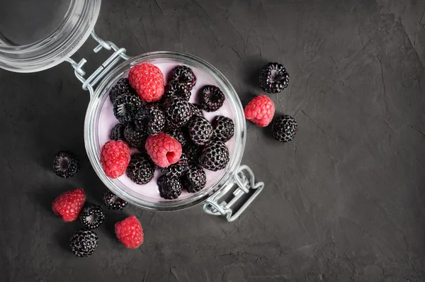 Yoghurt med svarta och röda hallon i glasburk — Stockfoto