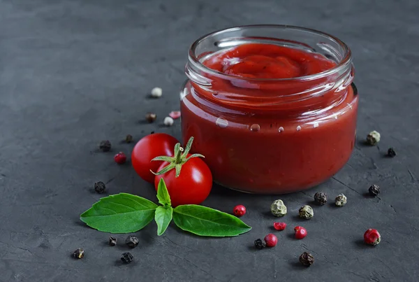 Tomato sauce and basil in glass jars — Stock Photo, Image