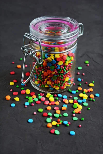 Produtos de confeitaria coloridos polvilhando em um frasco de vidro — Fotografia de Stock