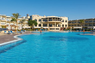 Lüks otelde palmiye ağaçları olan güzel bir yüzme havuzu. Mısır tatil köyünde güneşli bir gün