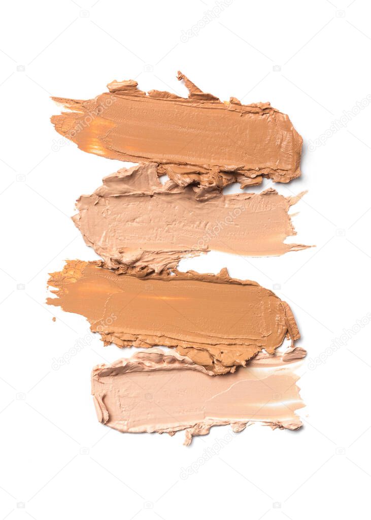 Shades of smudged brush strokes beige foundation or concealer as samples of cosmetic beauty products for correcting isolated on white background