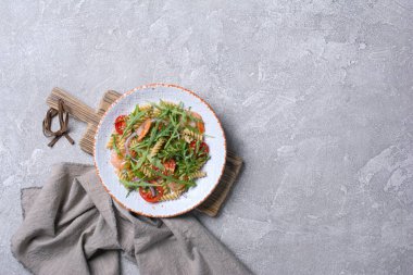 Karidesli, kiraz domatesli, soğanlı, susamlı ve yeşil roka yapraklı lezzetli makarna.