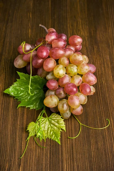 Uvas rosadas con hojas — Foto de Stock