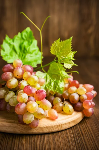 Uvas rosa maduras com folhas — Fotografia de Stock