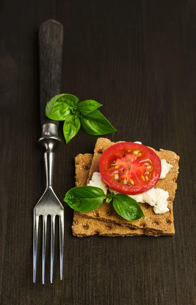 Rye bread with cheese, tomatoes and basil with a fork — Stock Photo, Image