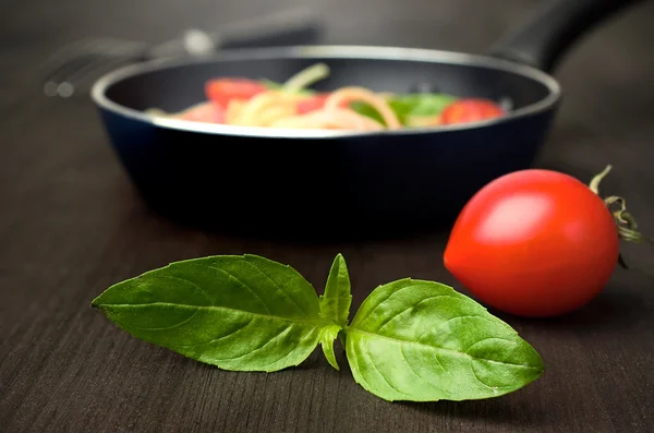 Tomato with fresh basil and a frying pan — Stock Photo, Image