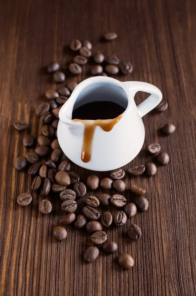 Koffie siroop met bonen op de houten achtergrond — Stockfoto