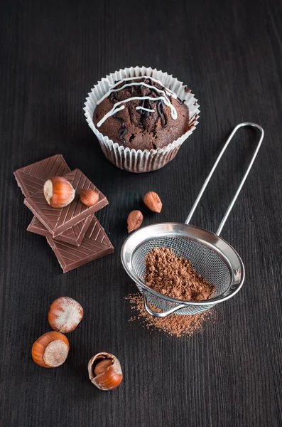 Chocolate muffins with cocoa , chocolate bars and hazelnuts — Stock Photo, Image