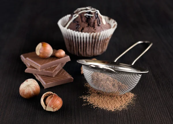 Chocolate muffins with cocoa , chocolate bars and hazelnuts — Stock Photo, Image