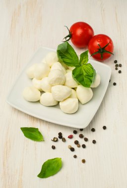  Mozzarella peyniri, domates ve fesleğen ahşap bir masa üzerinde