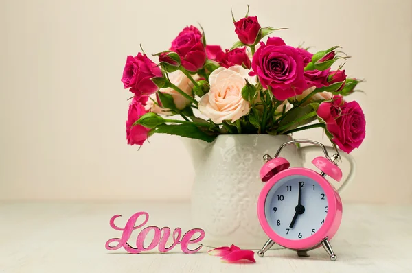 장미, 핑크 알람 시계와 단어 "사랑의 꽃다발" — 스톡 사진