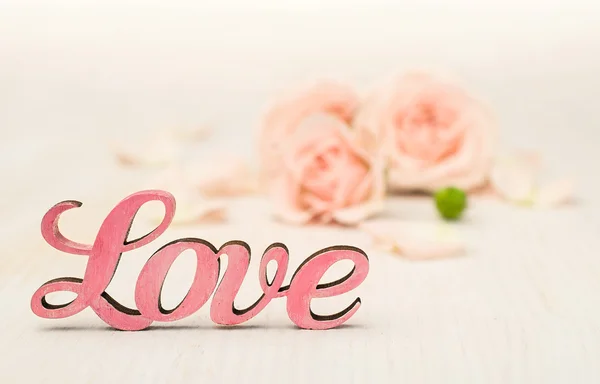 Pink word "love" and roses on the background — Stock Photo, Image