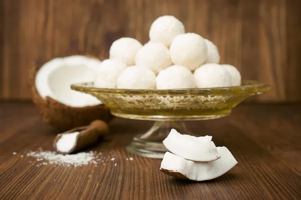 Candies in coconut flakes and fresh coconut — Stock Photo, Image