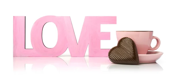 Pink word "love" with a cup and chocolate heart — Stock Photo, Image