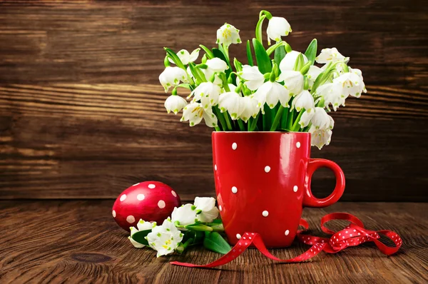 Gouttes de neige dans une tasse avec motif à pois et œufs peints — Photo