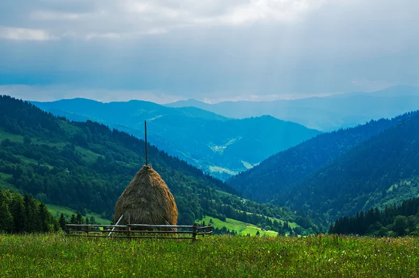 Haystack on a background of mountain ranges — Stock Photo, Image