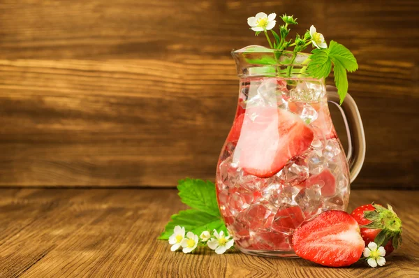 Orzeźwiający napój z truskawek i lodu w Dzbanek ze szkła — Zdjęcie stockowe