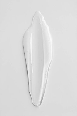 Tarafsız arkaplanda şeffaf kozmetik jel dokusu. Minimum güzellik kavramı berraklığı, saflığı ve modern cilt estetiğini sembolize eder..