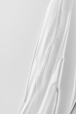 Tarafsız arkaplanda şeffaf kozmetik jel dokusu. Minimum güzellik kavramı berraklığı, saflığı ve modern cilt estetiğini sembolize eder..