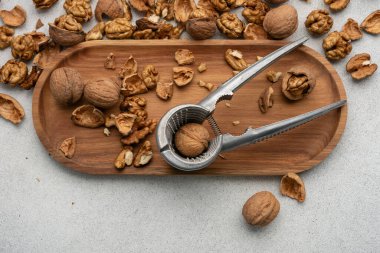 Dağınık ceviz kabuklu metal fındıkkıran. Doğal gıda, sadelik ve sağlıklı yaşam tarzı konsepti.