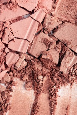 Gül tonlarında parıldayan ezilmiş kozmetik tozunun yakın çekimi. Güzellik, moda ve ürün kavramları için parçalanmış parçacıklar ve pigment parçalarıyla parçalanmış makyaj dokusu.