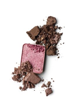 Beyaz arka planda ezilmiş pembe ve kahverengi göz farı. Parlak dokusu olan kırık kozmetik tozu. Güzellik reklamı ve tasarımı için yakın çekim ürünü.
